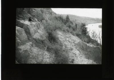 black and white lantern slide of rock bank along creek