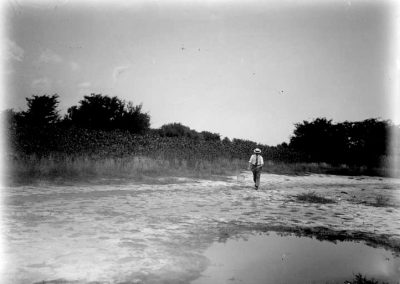 black and white photograph of saline pool shoreline and one man