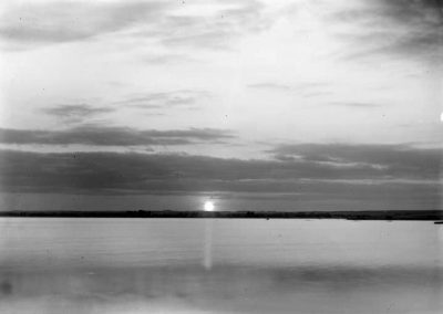 black and white photograph of sunset over lake