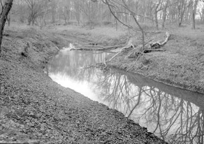 black and white photograph of creek and shore