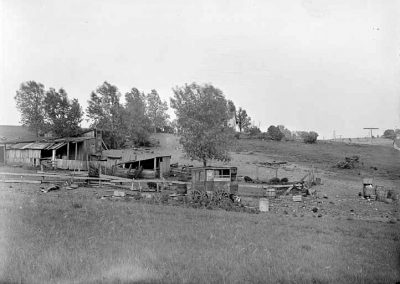 black and whtie photograph of farm buildings and wagon