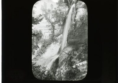black and white photo, with black border, of waterfall and some trees