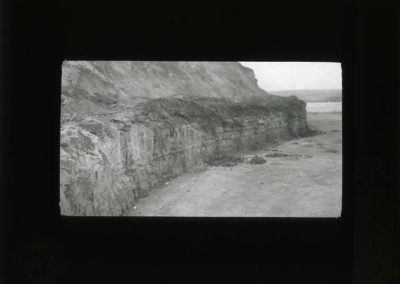 Black and white photograph of stone ledge along open area of a quarry