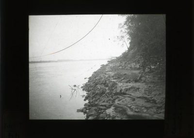 Black and white photograph of shoreline along a river.