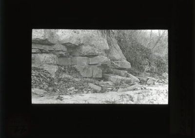 Black and white photograph of ledge and large rocks along bluff
