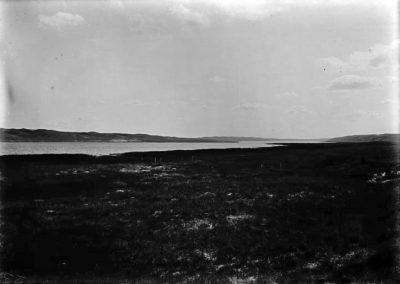 black and white photo of lake in distant and land in front