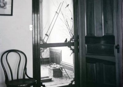 black and white photo of room interior with door and chair