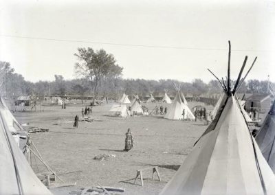 black and white photo of camp with tipis