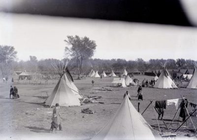 black and white photo of camp with tipis