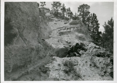 black and white photo of a man on rock bluffs